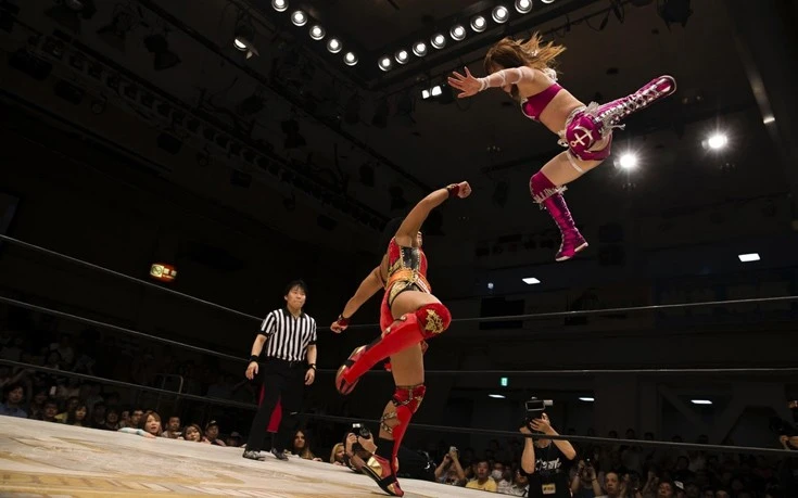 Stardom Joshi | Joshi wrestler Kairi Hojo executing her signature diving elbow drop from the top turnbuckle during a Stardom wrestling match.