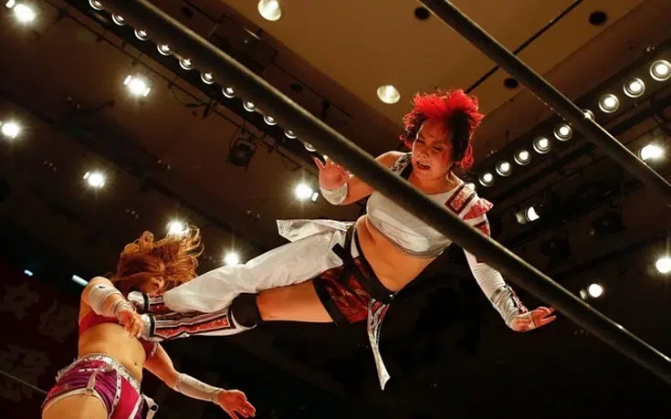 Stardom Joshi | Japanese joshi wrestler Act Yasukawa executing a high-flying dropkick on Kairi Hojo during a World Wonder Ring Stardom match.